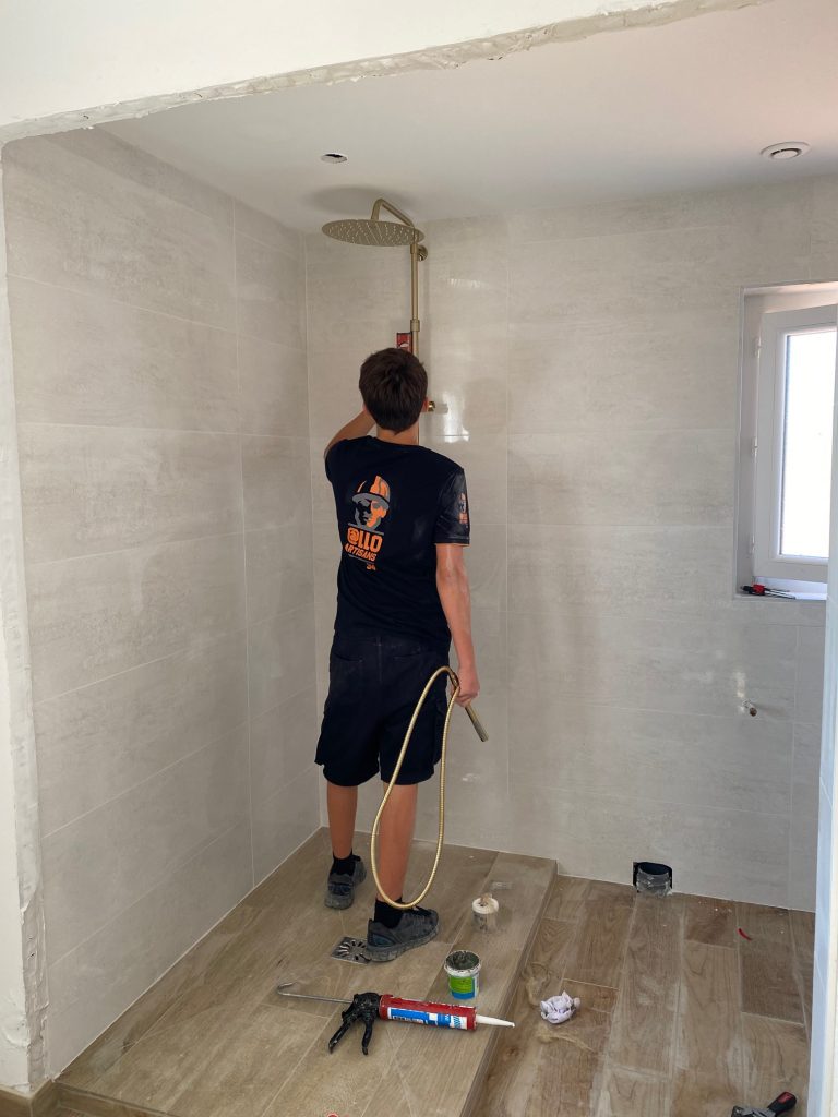 plombier installe un robinet de douche